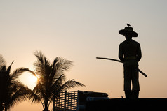 卡伦海滩普吉岛泰国2月黑暗轮廓纪念碑和棕榈树对的背景设置的太阳的卡伦海滩泰国卡伦海滩普吉岛泰国2月轮廓纪念碑和棕榈树对的背景设置的太阳的卡伦海滩泰国