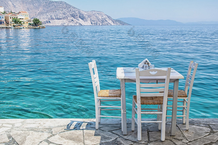 白色椅子与表典型的希腊酒馆附近的海锡米小镇椅子与表典型的希腊酒馆附近的海锡米小镇