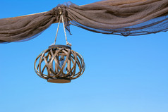 老木灯笼挂的绳子与宽松的窗帘对蓝色的清晰的天空老木灯笼挂的绳子与宽松的窗帘