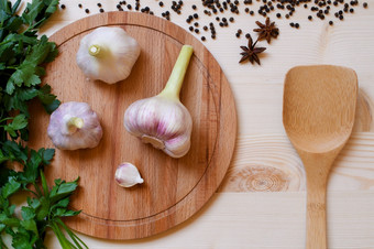 食物背景与新鲜的有机绿色香料和大蒜木板与竹子勺子食物背景与新鲜的绿色香料和大蒜木板与竹子勺子