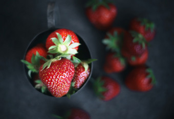 成熟的草莓<strong>分散</strong>周围铁杯子成熟的草莓<strong>分散</strong>周围铁杯子黑暗照片
