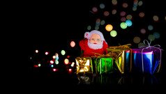 圣塔克罗娃娃与礼物盒子光散景背景快乐圣诞节和快乐新一年概念