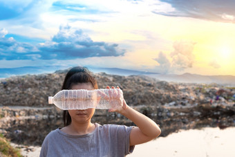 女人手持有使用清晰的塑料瓶封面的脸山大垃圾背景这些浪费来从城市和工业区域可以不得到掉桩臭和有毒残留