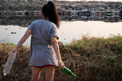 的回来女人站手有绿色玻璃瓶和清晰的塑料瓶山大垃圾背景这些浪费来从城市和工业区域可以不得到掉桩臭和有毒残留