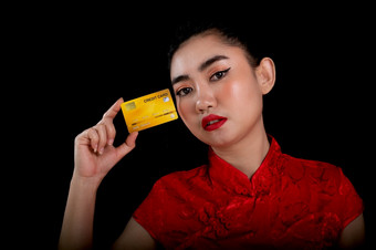 肖像美丽的年轻的亚洲女人红色的衣服传统的<strong>旗</strong>袍持有黄色的信贷卡的黑色的背景中国女孩中国人新一年概念看的相机