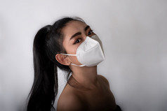 关闭年轻的亚洲女人把医疗面具保护从机载呼吸疾病的流感新冠病毒灰尘和烟雾灰色的背景安全病毒感染概念