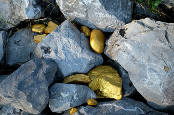 黄金<strong>金块</strong>和灰色花岗岩石头背景