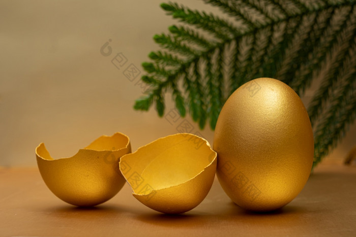金蛋和一半破碎的鸡蛋与蛋黄的金背景