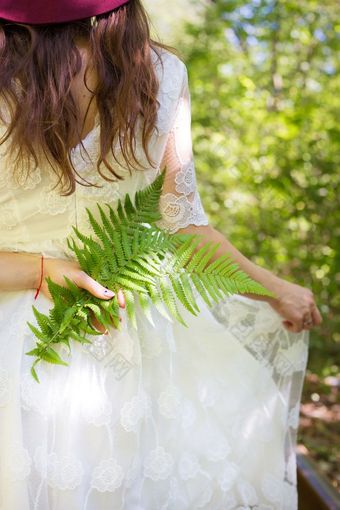 女孩白色衣服持有绿色蕨类植物叶子的森林女孩白色衣服持有绿色蕨类植物叶子森林