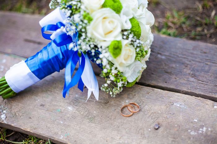 美丽的婚礼花束和环谎言木板凳上美丽的婚礼花束和环谎言木板凳上