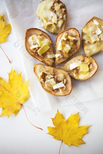 烤梨与布里干酪奶酪和坚果对的背景秋天黄色的叶子烤梨与布里干酪奶酪和坚果对的背景秋天黄色的叶子