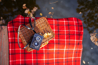 的老相机谎言手提箱红色的格子毯子木桥附近的湖的老相机谎言手提箱红色的格子毯子木桥附近的湖