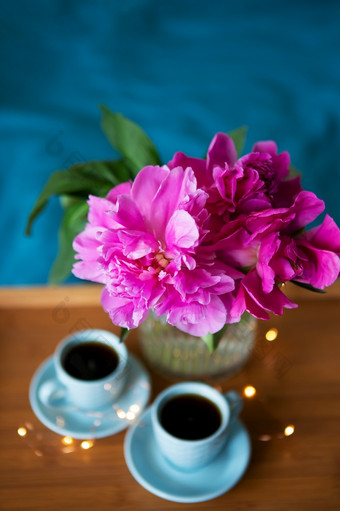 美丽的粉红色的牡丹和两个杯咖啡是站木托盘床上特写镜头美丽的早....美丽的粉红色的牡丹和两个杯咖啡是站木托盘床上特写镜头美丽的早....