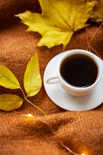 杯咖啡橙色毛衣黄色的叶子灯的背景温暖的秋天杯咖啡橙色毛衣黄色的叶子灯的背景温暖的秋天