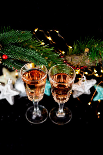 新一年和圣诞节装饰眼镜为香槟玩具为的圣诞节树站的表格前面的黑暗美丽的散景的背景特写镜头前视图新一年和圣诞节装饰眼镜为香槟玩具为的圣诞节树站的表格前面的黑暗美丽的散景的背景特写镜头前视图