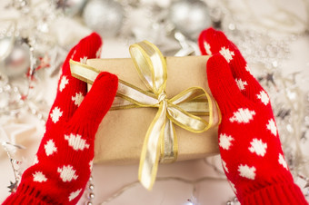 女手持有圣诞节礼物与黄金丝带红色的连指手套新一年情绪准备为的庆祝活动女手持有圣诞节礼物与黄金丝带红色的连指手套新一年情绪准备为的庆祝活动