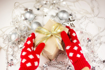 女手持有圣诞节礼物与黄金丝带红色的连指手套新一年情绪准备为的庆祝活动视图从以上女手持有圣诞节礼物与黄金丝带红色的连指手套新一年情绪准备为的庆祝活动视图从以上