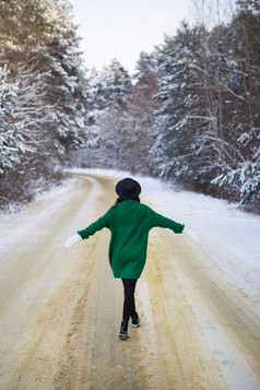 年轻的女孩绿色毛衣和他走的中间雪路厚松森林冻结一天年轻的女孩绿色毛衣和他走的中间雪路厚松森林冻结一天