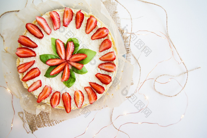 非常美丽的夏天芝士蛋糕装饰与草莓站白色木表格前视图非常美丽的夏天芝士蛋糕装饰与草莓站白色木表格前视图