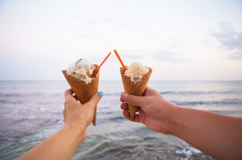 两个手持有美味的冰奶油夏天海滩两个手持有美味的冰奶油夏天海滩