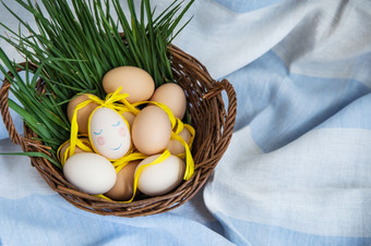 画复活节鸡蛋一个蛋与可爱的脸鸡蛋谎言木篮子沿着与绿色草明信片为复活节画复活节鸡蛋一个蛋与可爱的脸鸡蛋谎言木篮子沿着与绿色草明信片为复活节