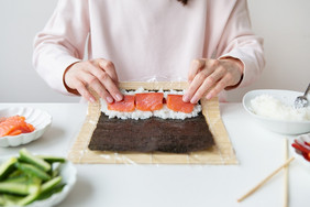 寿司准备过程的女孩使寿司与不同的口味新鲜