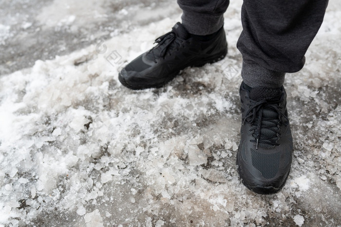 男人。冬天防水运动鞋站冰冷的路鞋子为冬天走走的开放空气男人。冬天防水运动鞋站冰冷的路鞋子为冬天走走的开放空气