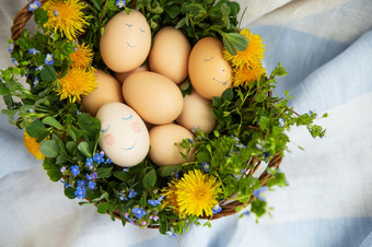 美丽的春天花束木篮子与复活节画鸡蛋鸡蛋与可爱的脸复活节明信片美丽的春天花束木篮子与复活节画鸡蛋鸡蛋与可爱的脸复活节明信片