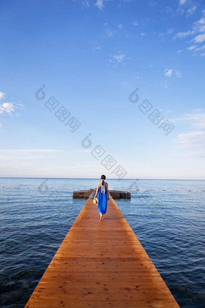 黑山共和国布德瓦女孩蓝色的衣服站木码头的海美丽的天空与云假期概念旅行欧洲黑山共和国布德瓦女孩蓝色的衣服站木码头的海美丽的天空与云假期概念旅行欧洲