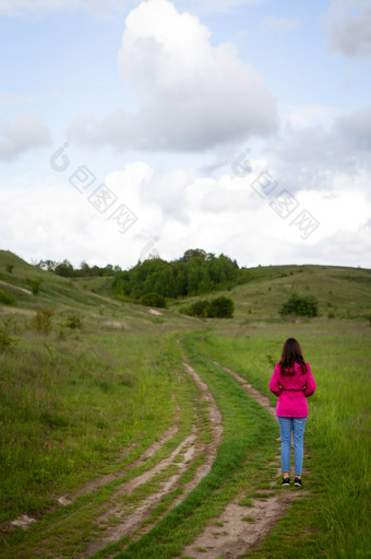 女人粉红色的雨衣看起来山路的概念徒步旅行的山徒步旅行户外娱乐女人粉红色的雨衣看起来山路的概念徒步旅行的山徒步旅行户外娱乐