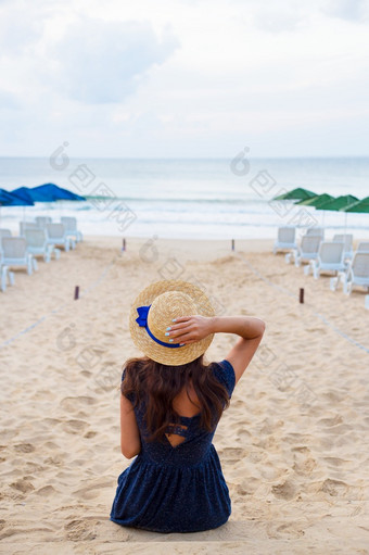 美丽的女孩他坐在与她的回来桑迪海滩和看<strong>起来</strong>海美丽的女孩他坐在与她的回来桑迪海滩和看<strong>起来</strong>海