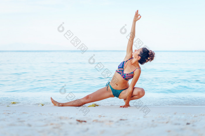 年轻的美丽的适合高加索人女人夏天女孩比基尼泳衣实践瑜伽的海滩的海海洋阳光明媚的一天伸展运动的假期