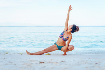年轻的美丽的适合高加索人女人夏天女孩<strong>比基尼泳衣</strong>实践瑜伽的海滩的海海洋阳光明媚的一天伸展运动的假期