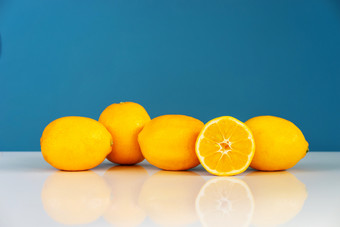 黄色的成熟的柠檬<strong>切</strong>片一<strong>半</strong>多汁的柑橘类<strong>水果</strong>的白色表格前面的蓝色的背景墙新鲜的<strong>水果</strong>