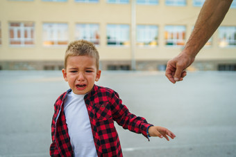 小男孩小孩子红色的衬衫哭而一些男人。<strong>尝试</strong>达到他