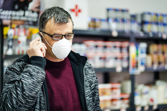 肖像高级高加索人男人。穿眼镜脸保护面具保护从病毒对流感反细菌保护健康问题疫情工作的地方商店使电话调用工作