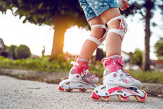 关闭孩子rsquo腿穿辊叶片溜冰鞋学习骑的沥青的学校院子里活动