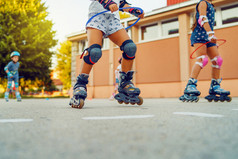 关闭孩子们rsquo腿穿辊叶片溜冰鞋学习骑的沥青的学校院子里活动