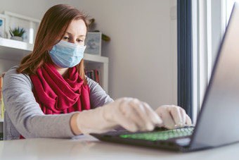 年轻的女人高加索人穿手套手和面具脸而工作从首页的办公室工作的表格移动PC一天防止病毒传播在<strong>疫情</strong>检疫<strong>预防</strong>