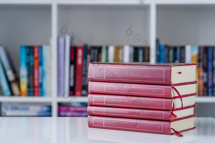 桩红色的书文学堆栈的白色表格前面的书架上背景首页一天前面视图