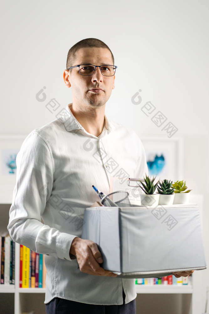 肖像成人高加索人男人。穿白色衬衫持有盒子个人项目的东西离开的办公室被解雇了从工作由于经济衰退经济危机经济低迷失去工作公司关闭