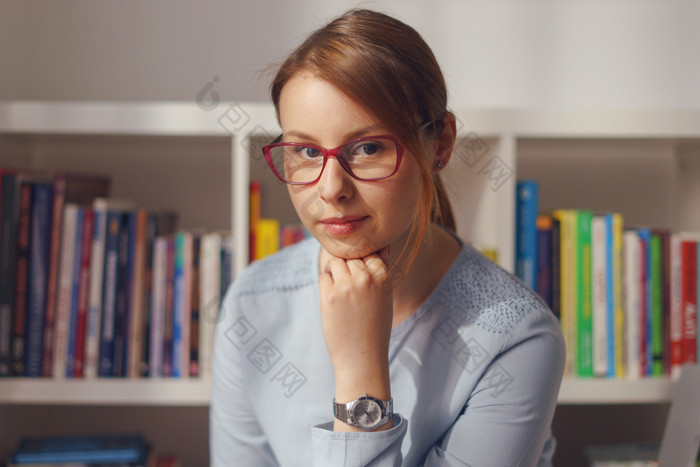 前面视图肖像美丽的年轻的成人高加索人女人女女孩坐着的椅子首页办公室前面的书架上倾斜头手穿眼镜衬衫一天