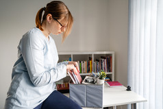 一边视图年轻的高加索人女人女女孩站的表格的办公室工作包装个人项目的东西的盒子后被解雇了从工作驳回了工作辞职由于危机经济衰退