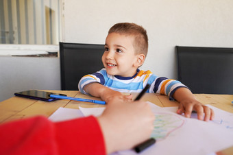 小高加索人男孩小孩子女人和儿子妈妈。和孩子坐着的表格的阳台阳台画与颜色铅笔的纸使用蜡笔的学习过程日益增长的