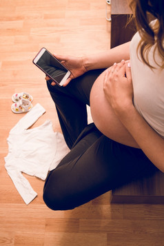 高角视图怀孕了女人妈妈。持有移动电话调用医院为交付出生婴儿紧急医生