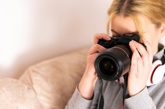 年轻的女人使用mirrorless数码单反相机相机夏天假期采取图片的假期的酒店大厅房间旅游