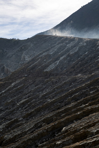 大胆的徒步旅行者走火山口Rim通过阴霾和烟