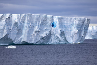 黑暗蓝色的彩虹色的冰洞穴巨大的冰山浮点数北极海洋