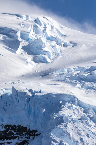 峰会山与蓝色的雪和层冰覆盖非常关闭对天空南极洲