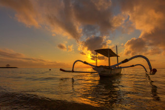 旅行的早....日出巴厘岛印尼传统的钓鱼船Sanur海滩巴厘岛印尼